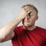 Image of male experiencing anxiety with hand on his head