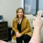 A therapist demonstrates EMDR (Eye Movement Desensitization and Reprocessing) therapy to a client, focusing on bilateral stimulation techniques to aid in emotional and cognitive processing.