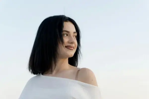 Woman looking to the side with a soft smile.