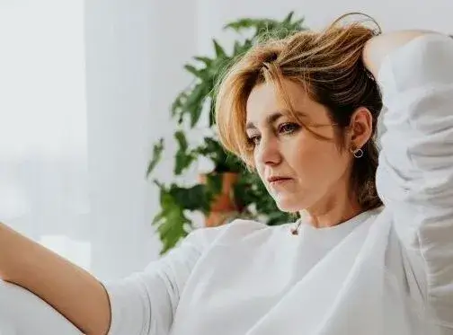 Women with hard hand in her hair, looking a bit sad.