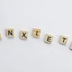 “Scrabble tiles spelling the word anxiety on a white background, symbolizing how high-functioning anxiety can be hidden in plain sight.”