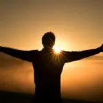 Person standing with open arms at sunrise symbolizing hope, calm, and relief from anxiety after EMDR and neurofeedback therapy in Conroe, Montgomery & The Woodlands Texas.