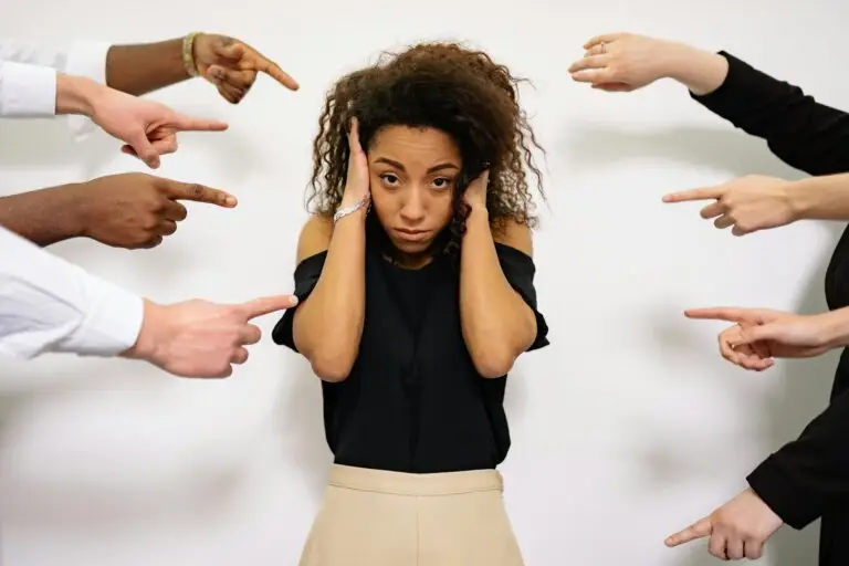 Woman experiencing social anxiety while surrounded by pointing hands, representing fear of judgment and emotional overwhelm often addressed in social anxiety therapy in Conroe, TX