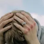 Person holding head in pain illustrating brain-based pain response and stress-related headaches