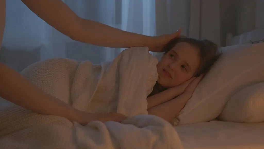 Child resting in bed with parent support while exploring neurofeedback therapy for sleep problems and bedwetting in Conroe TX