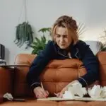 Woman appearing mentally overwhelmed while attempting to organize her thoughts, illustrating how ADHD symptoms often present differently in adult women.