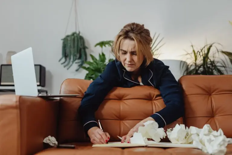 Woman appearing mentally overwhelmed while attempting to organize her thoughts, illustrating how ADHD symptoms often present differently in adult women.