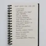 Notebook listing common ADHD symptoms including impulsivity, memory challenges, emotional regulation difficulties, and focus problems.