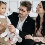 Adoptive parents interacting with their young daughter, illustrating secure attachment, emotional connection, and trauma-informed support for adopted children.
