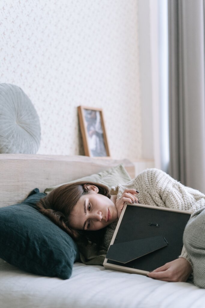 Woman grieving while holding a framed photo – grief counseling in Conroe TX
